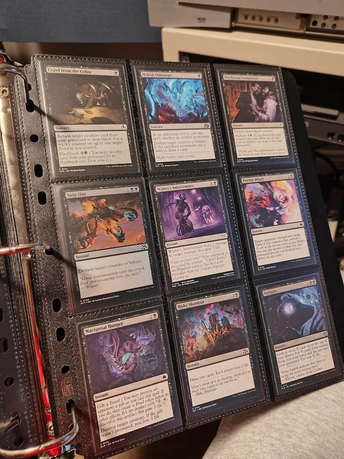 A D-ring binder containing a page of Magic: The Gathering cards